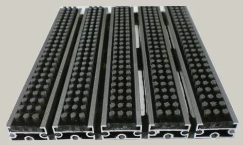 Zerbino tecnico composto da profili portanti in alluminio estruso antitorsione corredati da apposita guarnizione fonoassorbente nel lato inferiore. Parte di calpestio composta da spazzole a listello allineate parallelamente resistente alle intemperie Zerbino adatto al posizionamento in ambiente interno ed esterno. Base alluminio mm 8/13/17 