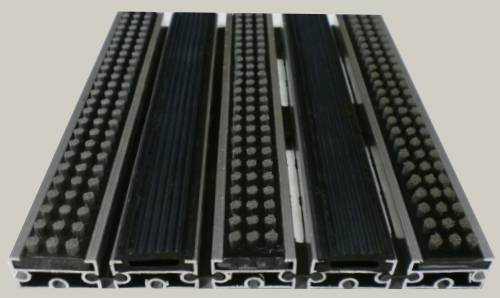 Zerbino tecnico composto da profili portanti in alluminio estruso antitorsione corredati da apposita guarnizione fonoassorbente nel lato inferiore. Cerniere drenanti e piene per permettere l ‘aspirazione senza sollevare lo zerbino. Parte di calpestio composta da gomma EPDM millerighe e spazzole in Nylon
						Zerbino adatto al posizionamento in ambiente esterno. Base alluminio mm 8/13/17 