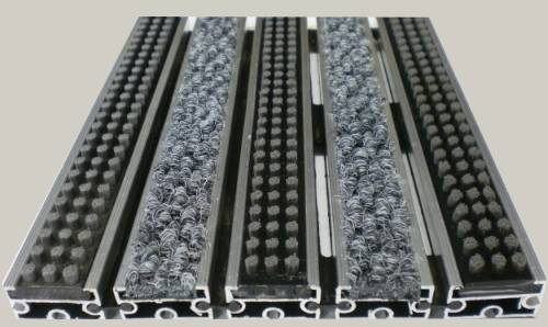 Zerbino tecnico composto da profili portanti in alluminio estruso antitorsione corredati da apposita guarnizione fonoassorbente nel lato inferiore. Cerniere drenanti e piene per permettere l ‘aspirazione senza sollevare lo zerbino. Parte di calpestio composta da Polipropilene 100 % e spazzole in Nylon. Zerbino adatto al posizionamento in ambiente interno ed esterno coperto. Base alluminio mm 8/13/17 